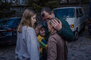 Denys Zaporozhchenko reunites with his children, Dayana, Yana and Nikita, in Kyiv, Ukraine, March 22, 2023. (Daniel Berehulak/The New York Times)