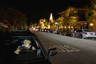 Brantley Bush in his car outside Porta Via Beverly Hills, hoping to catch a delivery app order from the restaurant in Los Angeles, Dec. 9, 2022. (Mark Abramson/The New York Times)