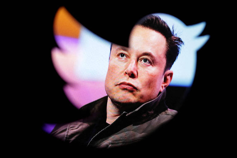 Elon Musk, um homem branco, de cabelos castanhos e arrepiados, aparece por trás de um logo do Twitter, a silhueta de um pássaro.