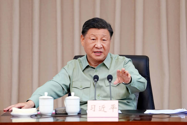 O presidente chinês Xi Jinping, também secretário geral do Partido Comunista da China e da comissão central militar, fez discurso à marinha chinesa. Ele é um homem asiático, de cabelos lisos e pretos, vestido em camisa social verde militar.