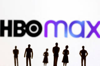 FILE PHOTO: Toy figures of people are seen in front of the displayed HBO Max logo, in this illustration