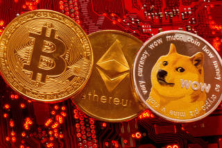 FILE PHOTO: Representations of cryptocurrencies Bitcoin, Ethereum and DogeCoin are placed on PC motherboard in this illustration taken