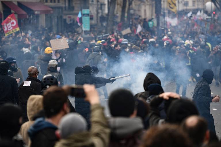 Manifestante aponta fogos de artifício durante confronto com a polícia durante protesto em Paris