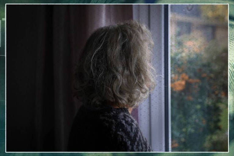 Foto mostra mulher de cabelos claros virada de costas e olhando para paisagem em janela