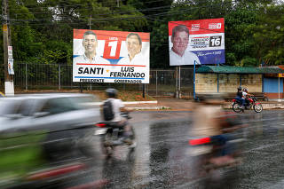 People drive past an electoral advertisement in Asuncion