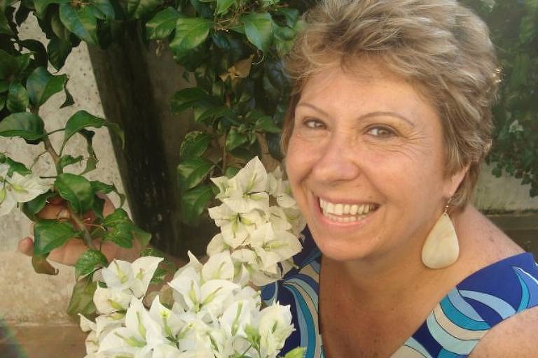 A pediatra Maria Lúcia Pettinati diante de flores brancas