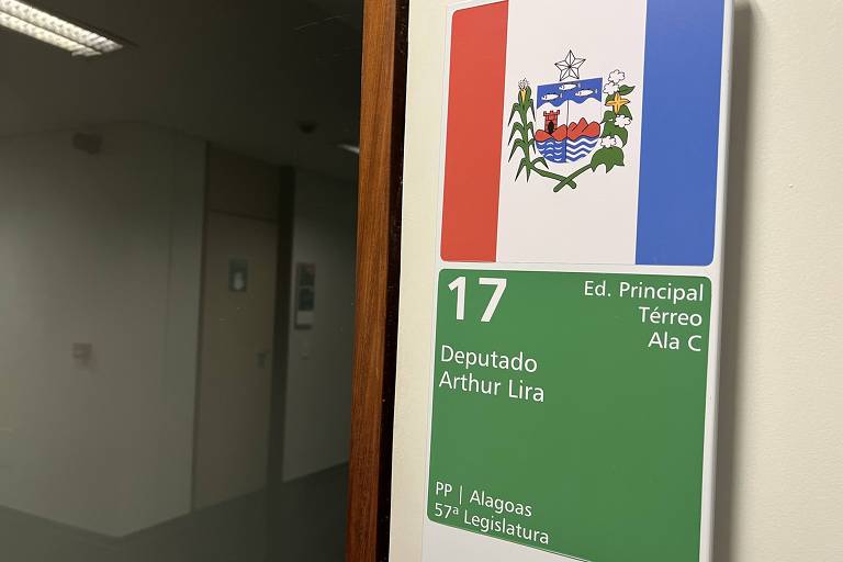 Porta de entrada do gabinete com a placa de identificação que consta a bandeira de Alagoas e o nome de Arthur Lira