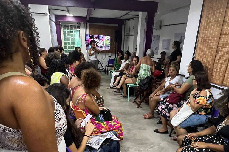 Imagem colorida mostra grupo de mulheres sentadas em roda de conversa na ONG Redes da Maré, no Rio