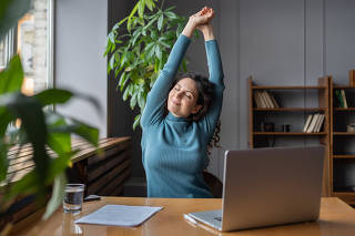 Happy business woman stretching at workplace, female employee resting from computer screen