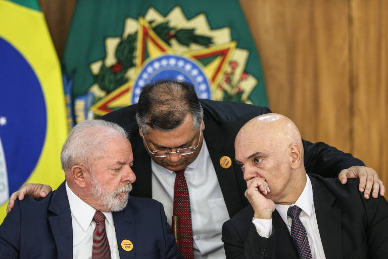 Ao centro, Dino coloca a mão sobre os ombros de Lula e Moares enquanto conversam