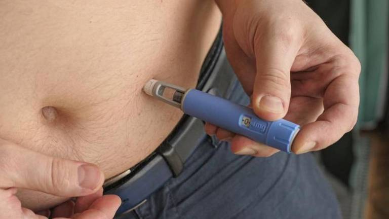 Homem aplica remédio Ozempic na barriga com uma caneta aplicadora