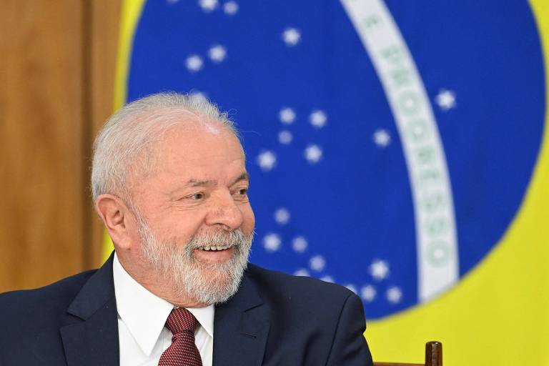 Presidente Lula em frente à bandeira do Brasil