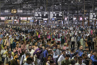 Daily commuters wait for the suburban train on the platform of CST station in Mumbai, India, in April 17, 2023. (Atul Loke/The New York Times)