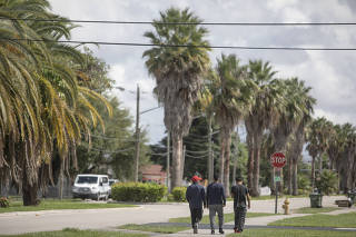 Three boys from Guatemala, who were released to the same sponsor and work full time in construction, walk down a street in Homestead, Fla., Aug. 20, 2022. (Kirsten Luce/The New York Times)