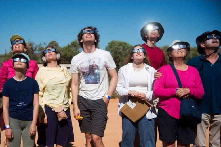 Pessoas usam óculos escuros para assistir ao eclipse solar