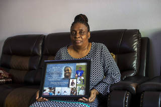 Lisa Banks holds a framed memorial of her son, Omarian Banks, at her residence in Riverdale, Ga, on April 20, 2023. (Alyssa Pointer/The New York Times)