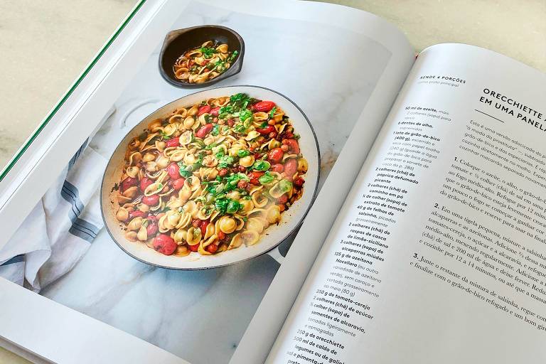 A foto mostra um livro aberto com uma foto de um prato de massa orecchiette e a receita na página ao lado