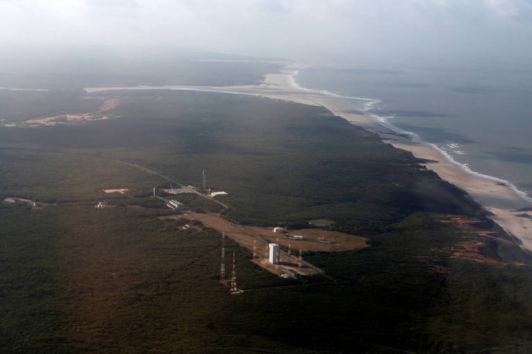uma base de lançamento de foguetes numa área verde com litoral
