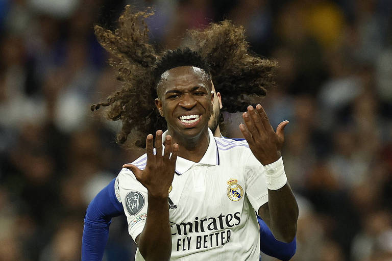 Usando uniforme branco, Vinicius Junior posicionado à frente do cabeludo Cucurella em jogo das quartas de final entre Real Madrid e Chelsea no Santiago Bernabéu, pela Champions League