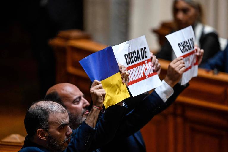 Parlamentares do Chega levantam cartazes contra a corrupção e com a bandeira da Ucrânia durante fala de Lula no Parlamento luso, em Lisboa
