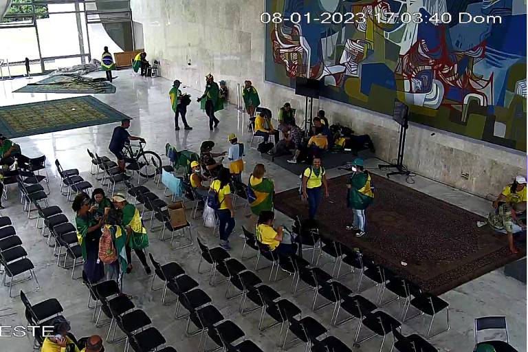 pessoas vestidas de verde e amarelo usam de forma recreativa sala com cadeiras para cerimônias