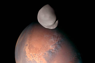 A composite image of Deimos, captured by the Emirates Mars Mission, over Mars. (Emirates Mars Mission via The New York Times)