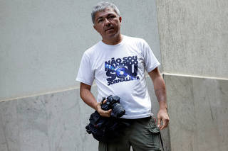 Journalist Wellington Macedo wears an electronic monitoring ankle-bracelet before a news conference of the Brazil's Liberal Party President Valdemar Costa Neto in Brasilia