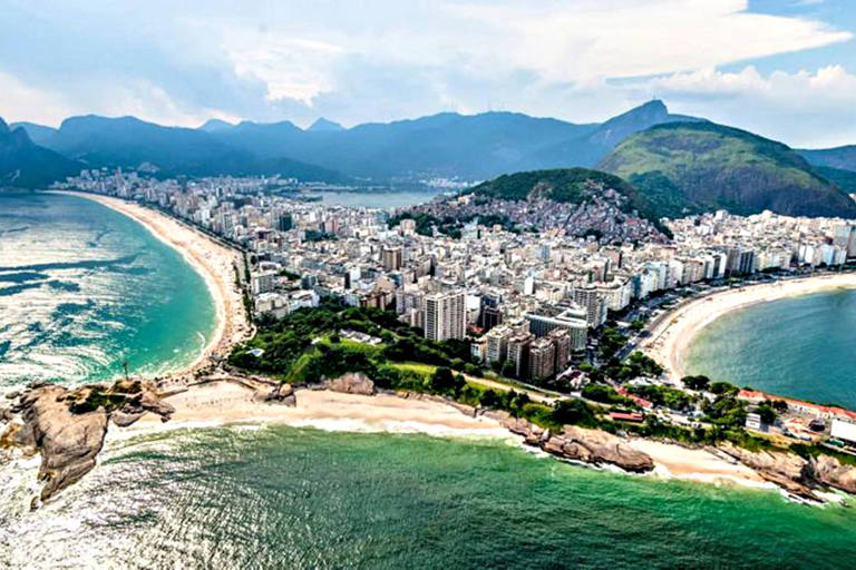 O programa de visto de nômade digital quer atrair visitantes com dinheiro para o Rio. Imagem aérea do Rio de Janeiro exibe paisagens urbanas, em meio a praias, mares e morros