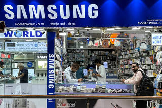 FILE PHOTO: People shop inside a store selling Samsung mobile phones and accessories in Mumbai