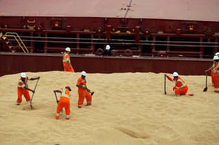 FILE PHOTO: Employees working at cargo ship Kypros Land which is loading soybeans to China at Tiplam terminal in Santos