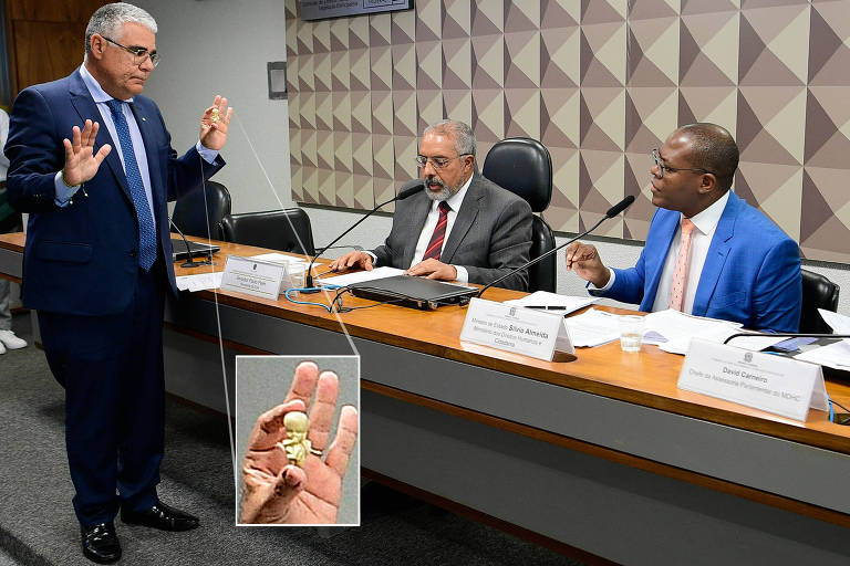O senador Eduardo Girão (Novo-CE), à esq., exibe réplica de feto ao ministro Silvio Almeida (à dir.)
