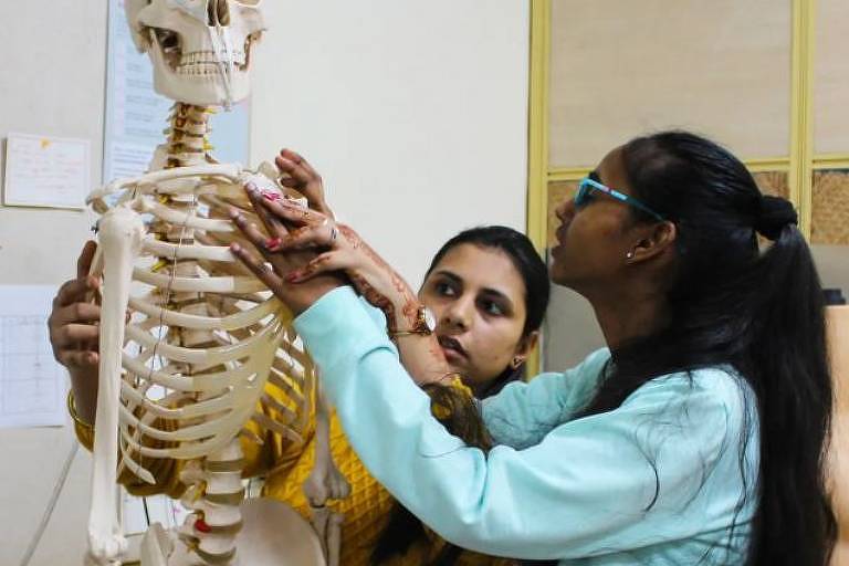 Mulheres jovens tateiam esqueleto artificial durante treinamento