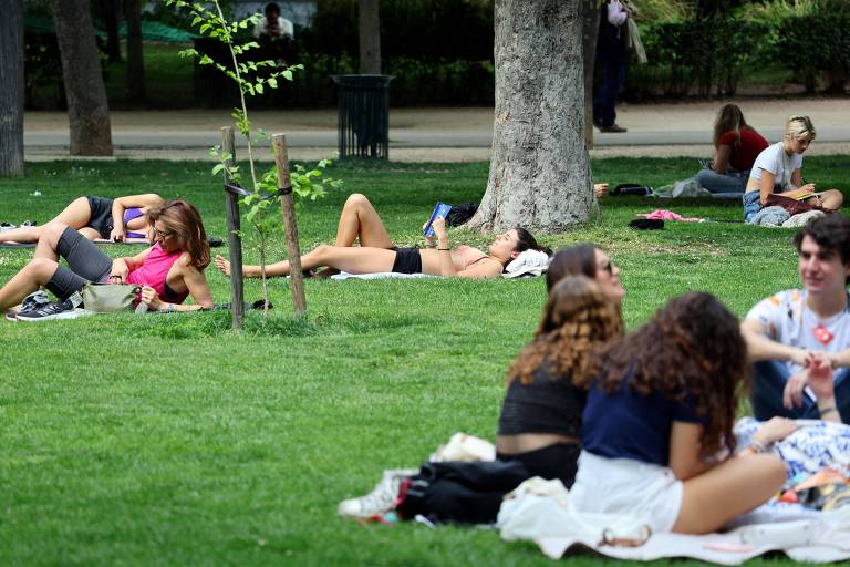 pessoas descansam na grama no parque do Retiro, no centro de Madri