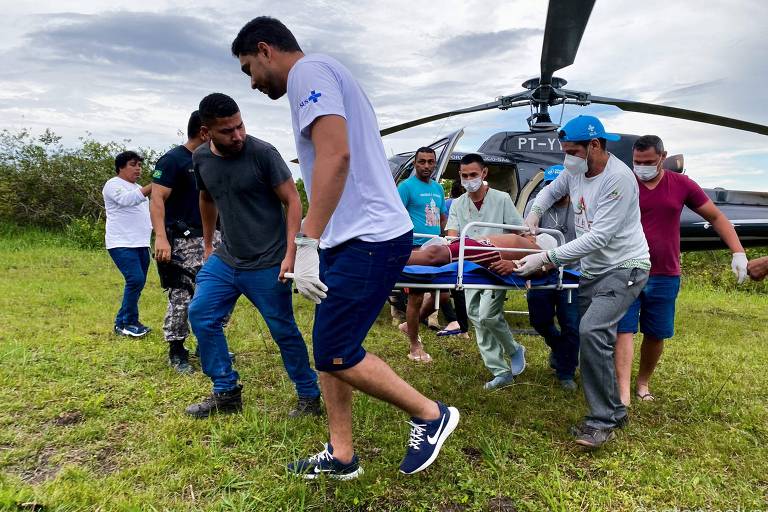 Agentes de saúde socorrem um indígena ferido por garimpeiros no ataque realizado na Terra Indígena Yanomami de Alto Alegre, em Roraima