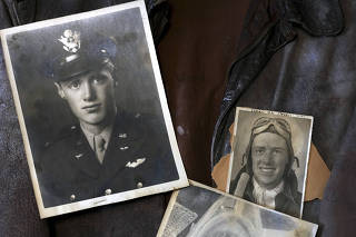 Old photographs are displayed against a bomber jacket belonging to the military veteran John Wenzel, now nearly 100 years old, in his apartment in New York on Aug. 26, 2023. (Michelle V. Agins/The New York Times)