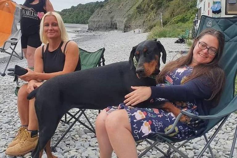 Mulheres na praia com cachorro
