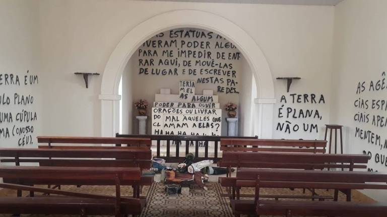 Altar da capela Nossa Senhora da Piedade, em Araras (SP), pichado com as imagens de santos quebrados no chão