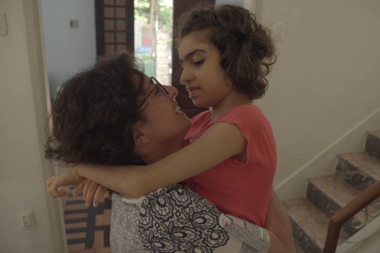 Margarete Brito segura a filha Sofia Langenbach no colo, que abraça a mãe, em cena do documentário 'O Outro Mundo de Sofia'
