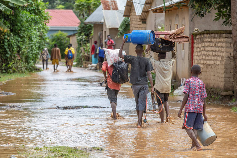 Moradores retiram pertences em meio a enchente no distrito de Rubavu, na Província Ocidental de Ruanda