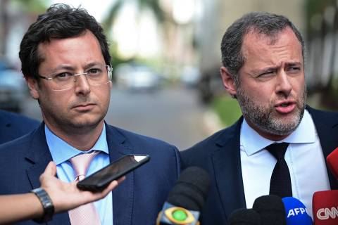 Frmer Brazilian Communication Secretary Fabio Wajngarten (L) and the lawyer of Brazilian former President Jair Bolsonaro, Paulo Cunha Bueno, speak to media after Bolsonaro went to the Federal Police headquarters to testify in Brasilia on April 26, 2023. - Bolsonaro arrived to the federal police headquarters in Brasilia to testify about the January 8 riot in the Brazilian capital, when thousands of his followers invaded the headquarters of the three powers, a police source confirmed. (Photo by TON MOLINA / AFP)