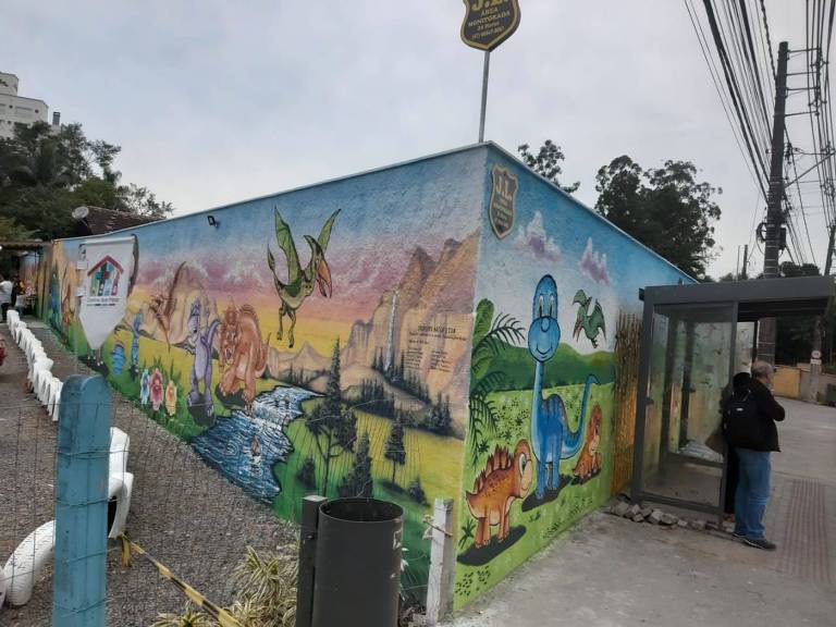 muro pintado de dinossauro em creche