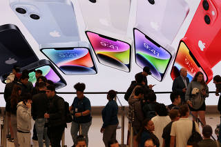 FILE PHOTO: Customers queue at the Apple Fifth Avenue store for the release of the Apple iPhone 14 range in Manhattan, New York City