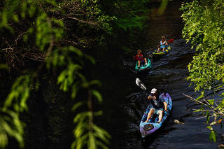 A family kayaks through Riverbend Park on the Loxahatchee River in Jupiter, Fla. on Thursday, March 16, 2023. (Scott McIntyre/The New York Times)