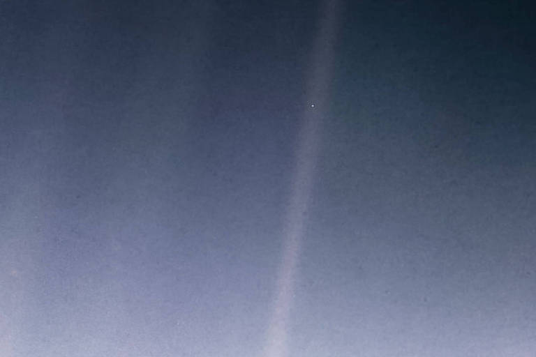 Imagem da Terra (ponto pálido azul) vista do Voyager 1 a uma distância de 6 bilhões de quilômetros do Sul