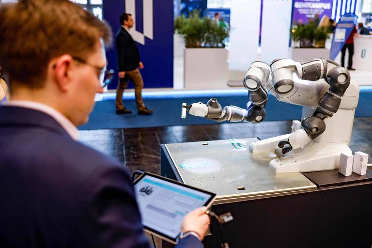 Arquiteto de dados opera robô capaz de falar e responder questões em evento de tecnologia em Hanover, na Alemanha