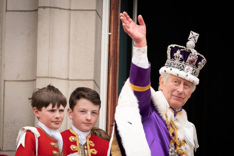 O rei Charles 3º acena ao público do Palácio de Buckingham, em Londres, após a cerimônia de cororação