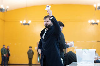 Chile's President Gabriel Boric prepares to cast his vote at a polling station during elections for a new assembly to draft constitution, in Punta Arenas