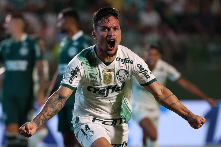 Usando uniforme branco, com os braços abertos, o punho cerrado e gritando, Artur, do Palmeiras, comemora gol na goleada por 5 a 0 sobre o Goiás, em Goiânia, pelo Campeonato Brasileiro