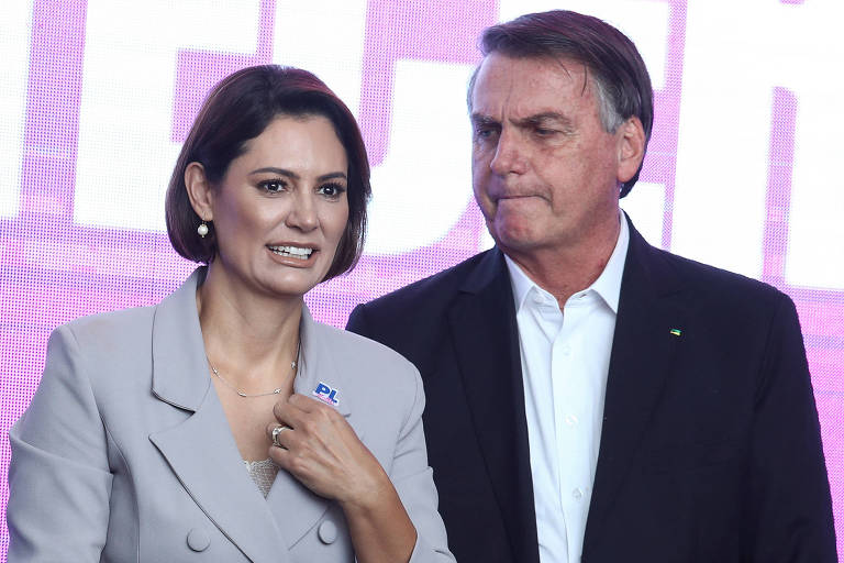 O ex-presidente Jair Bolsonaro, de terno à direita, e a ex-primeira-dama Michelle Bolsonaro, à esquerda, em evento do PL em SP