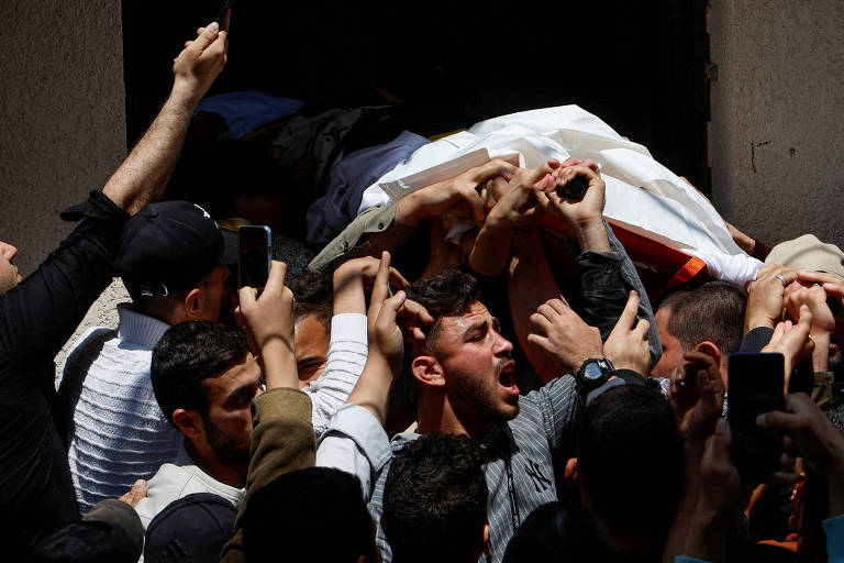 Pessoas carregam corpo de um dos dirigentes do Jihad Islâmico morto durante ataque de Israel à Faixa de Gaza